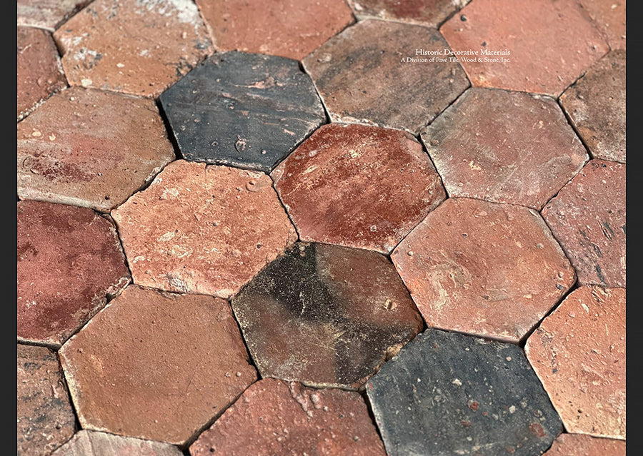 Antique French reclaimed hexagonal tiles in shades of red brown and black is an appealing aesthetic for entryways.
