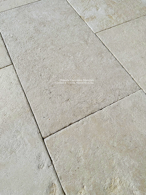 Installing antique French limestone in a running bond pattern around the patio deck and outdoor kitchen is beautiful.