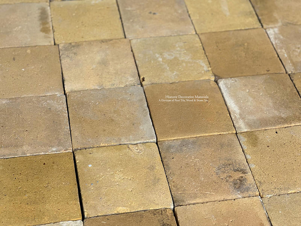 A French farmhouse kitchen with butter yellow French reclaimed terra cotta tiles and a navy La Canche range is the top.