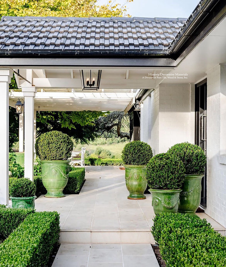 Small and large French potteries from Provence grouped in front of an entryway is warm and inviting.