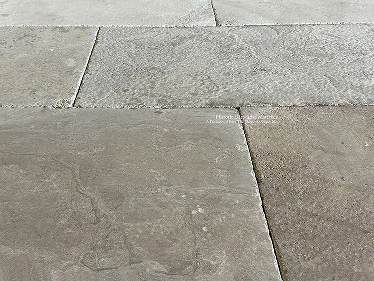 Warm brown tones of antique French limestone floors create historic ambiance in a home.