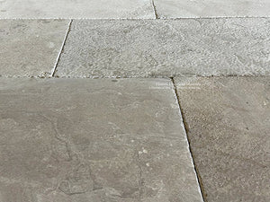 Warm brown tones of antique French limestone floors create historic ambiance in a home.