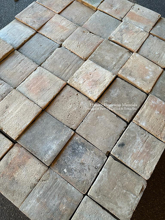 A square French reclaimed terra cotta tile in a variety of gray colors creates a lovely powder room floor.