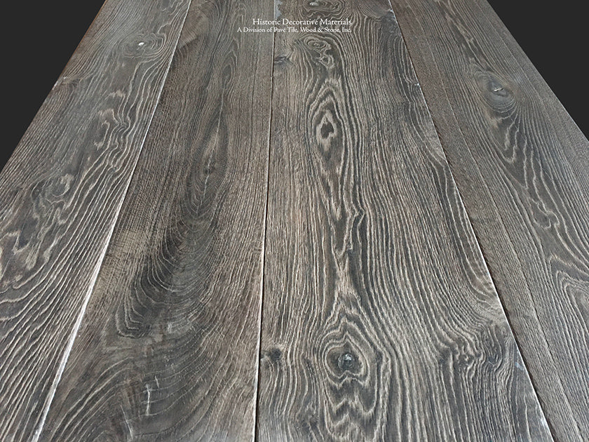 Wide-plank reclaimed French oak flooring in charcoal and oak patina enriches historic interiors.