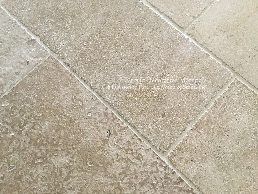Antique French limestone floors in soft ivory colors are beautiful with painted kitchen cabinets.